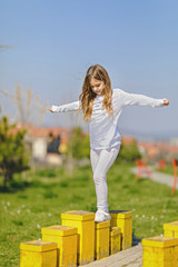 Young girl balancing at playground. Balancing concept. 