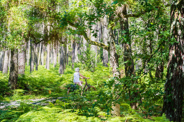 femme à la retraite faisant du vélo dans la magnifique forêt des Landes