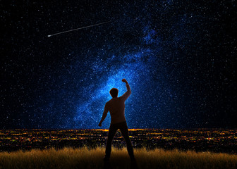 Man in front of the city and the universe with gestures of triumph and success