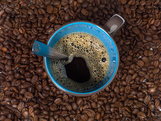 tasse de café entouré de grains de café vu de dessus