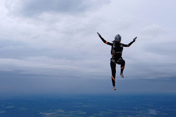 Fototapeta na wymiar Skydiving. The alone girl is in the sky.