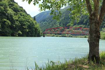 秘境のような美しい川と緑と赤い橋