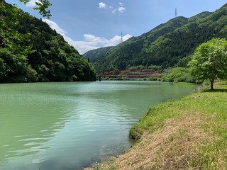 秘境のような美しい川と緑と赤い橋
