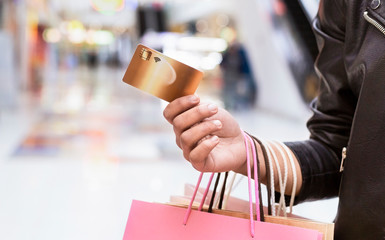 Young african woman holding gold credit card