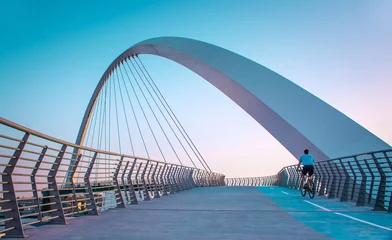  Jonge man fietst door de waterkanaalbrug van Dubai, Beautiful Architecture Design © sarath