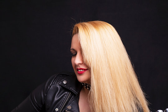 Beautiful blonde girl in rock style on a black background.