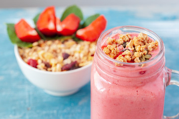 Bowl of homemade granola with yogurt and fresh berries on wooden background