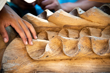 Closeup hands of local craftman carve teak timber with chisel tool create delicate handcraft art in...
