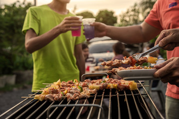 Naklejka premium BBQ party group of people at barbecue dinner friends having food together outdoor as summer with friendship asian person.