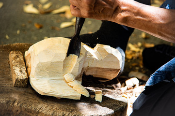 Closeup hands of local craftman carve with gouge tool and create an amazing Thai Northern handcraft art in Thailand.
