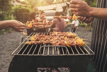 BBQ party group of people at barbecue dinner friends having food together outdoor as summer with...