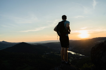   Tourist in blue black sportswear and green backpack stay on view point and watch standing on...