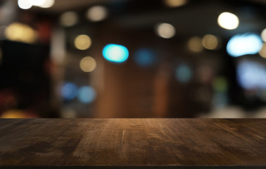 Empty dark wooden table in front of abstract blurred bokeh background of restaurant . can be used for display or montage your products.Mock up for space.