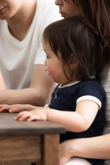 子供にタブレットを見せる両親