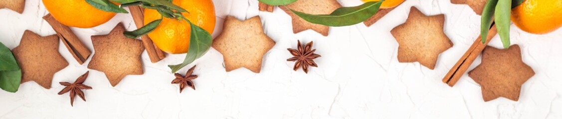 Obraz na płótnie Canvas Border of Christmas star cookies with spices and mandarin on white background with copyspace.