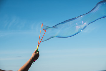 Large, soap bubbles against the blue sky. Lake Ladoga, sunny day.