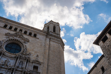 Fototapeta na wymiar Girona's Cathedral main landmark, high church tower on a diagonal composition on a blue cloudscape