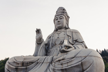 Fototapeta na wymiar Stone sitting Buddha statue in peaceful location