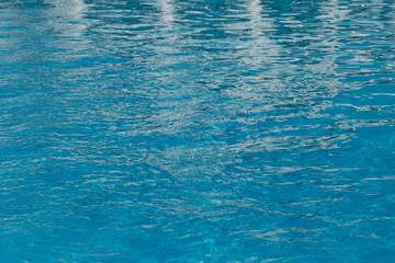Blurred water texture in summer pool close up.