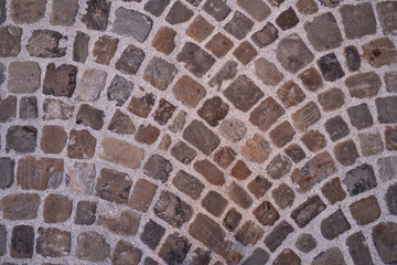 Stone pavement texture. Abstract background of old cobblestone pavement close-up