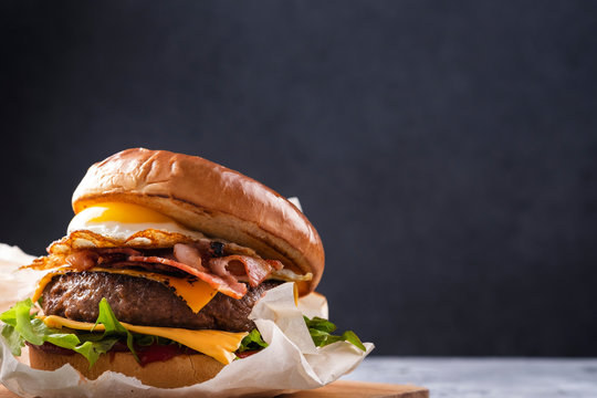 Juicy burger with fried egg and bacon. Street food. Fastfood. Copy space