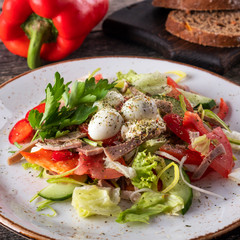 Beef tongue, vegetables and quail egg salad. Closeup