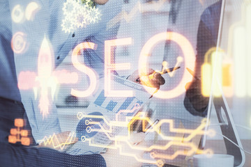Multi exposure of seo icon with man working on computer on background. Concept of search engine...