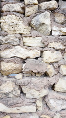 wall made of roughly treated natural stone with cement mortar