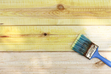 old tassel on painted pine planks top view. protective wood impregnation