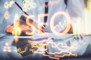Double exposure of woman's hands making notes with SEO icon. Concept of Search engine optimization