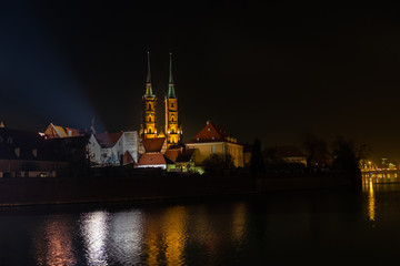 Fototapeta premium Amazing night view of the Cathedral of St. John the Baptist reflected in Oder river. Ostrow Tumski district. Wroclaw. Poland