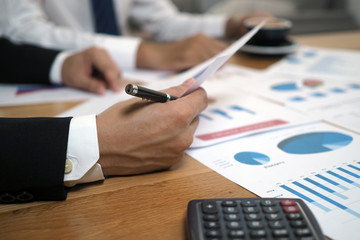 Businessmen together brainstorm ideas for calculating statistical data of investment budgets, making new projects.