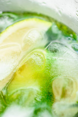 Refreshing summer Mojito drink with lime, mint and ice close-up