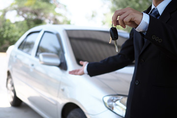 Car salesmen and keys presenting car trading