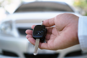The car owner is standing the car keys to the buyer. Used car sales