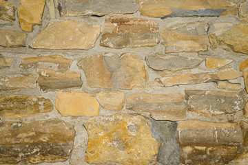 the surface of the old wall of beige stones