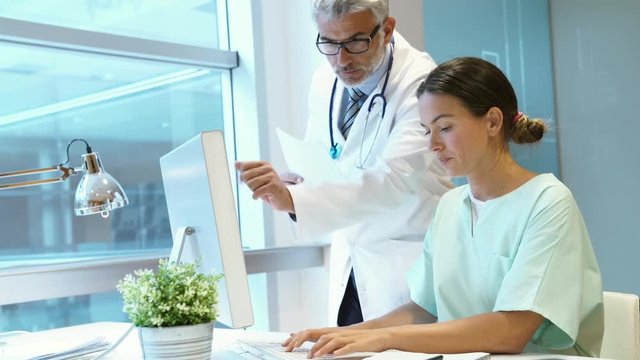 Doctor and nurse discussing patient results in hospital office