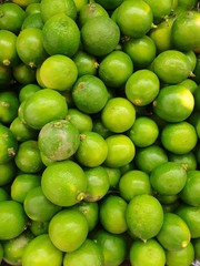 Top view of fresh lemons as a background for sale in the supermarket, for making drinks or cooking, healthy food concept, Vertical