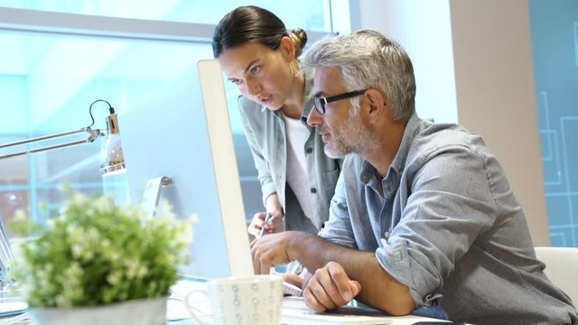 Coworkers discussing business in modern office