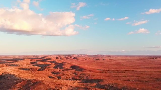 Beautiful forward flying aerial shot of large red sand hills in the Australian outback desert.