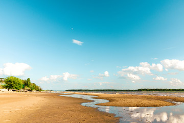 Summer sunny day at the sea. Summer seascape with reflected clouds in the water