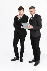 Two attractive confident businessmen wearing suits