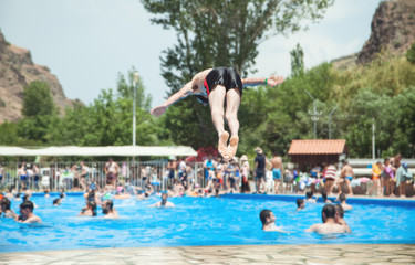 Naklejka premium Man jumps into a pool with blue water.