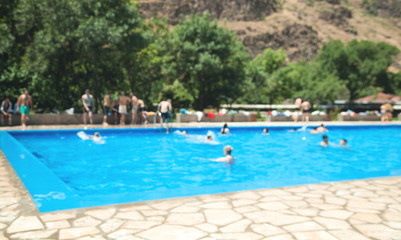 Fototapeta premium Defocused view. People in the swimming pool