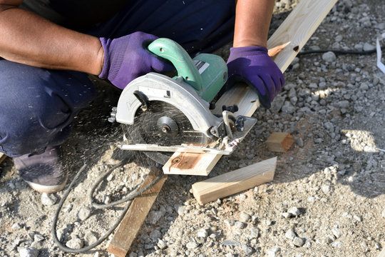 Carpenter work: cut wood with circular saw at the construction site of a house.