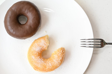 Glazed donut and chocolate donut on white background