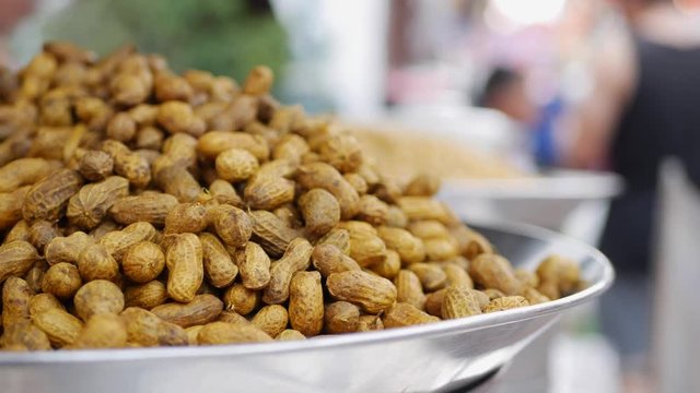 Steaming peanuts for sale at market. Street food. 4k