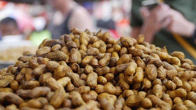 Steaming peanuts for sale at market. Street food. 4k