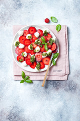 Summer fruit caprese salad with strawberries. Strawberry salad with basil pesto and mozzarella.