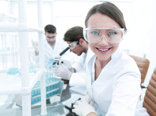 Investigator checking test tubes, Woman wears protective goggles